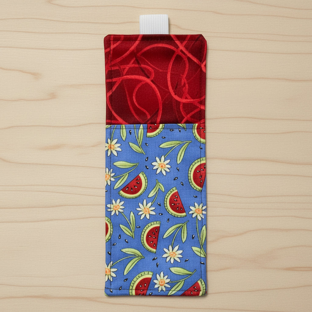 Rectangular fabric pouch with red top and blue bottom featuring watermelon and flower pattern