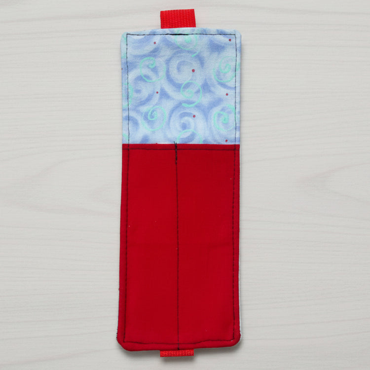 Rectangular fabric pouch with red bottom half and blue top half with swirl pattern on a white background