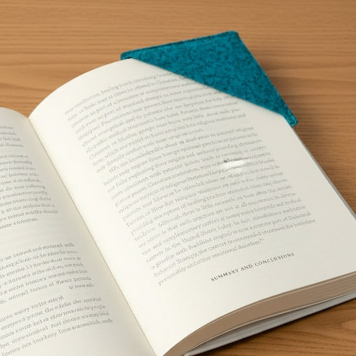 Open book with a teal fabric bookmark 