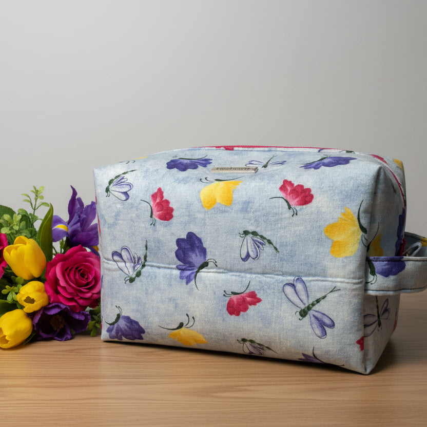 Floral and insect-patterned bag on a white background