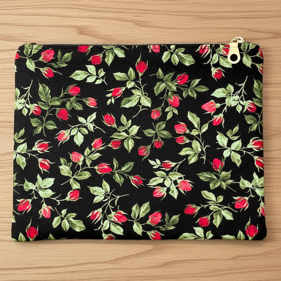Floral patterned pouch with red flowers and green leaves on a black background