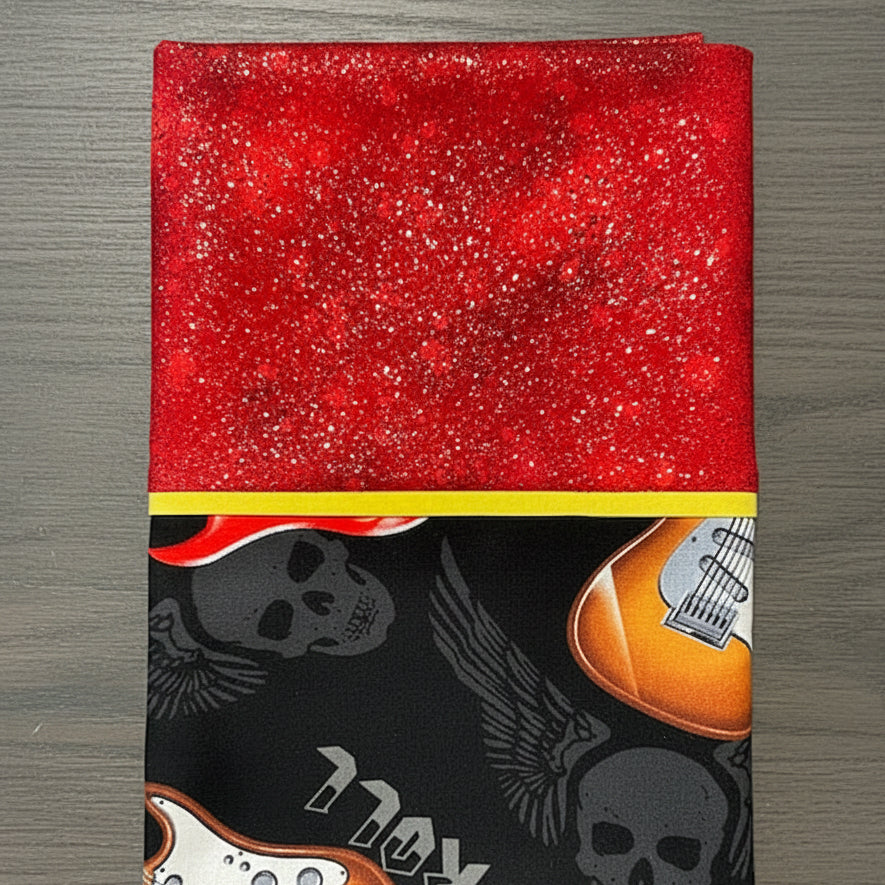 Pillowcase with red and black designs featuring guitars and skulls on a white background