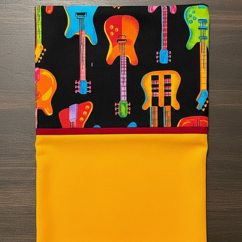 Pillowcase with colorful guitar pattern on a black background,