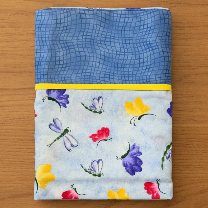 Pillowcase with blue grid pattern at top and colorful butterfly design at bottom 
