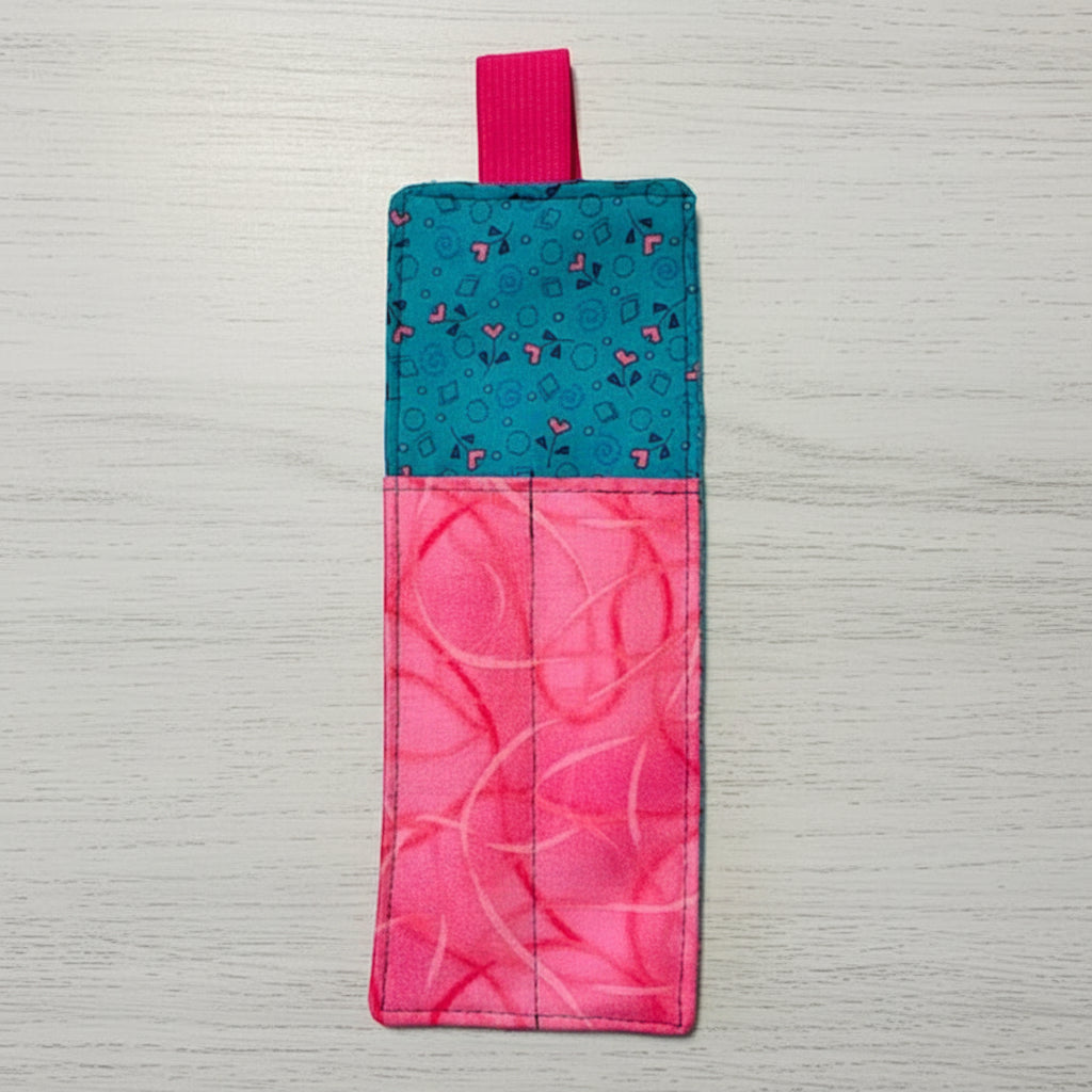 Two-tone pink and blue fabric bookmark on a light gray background
