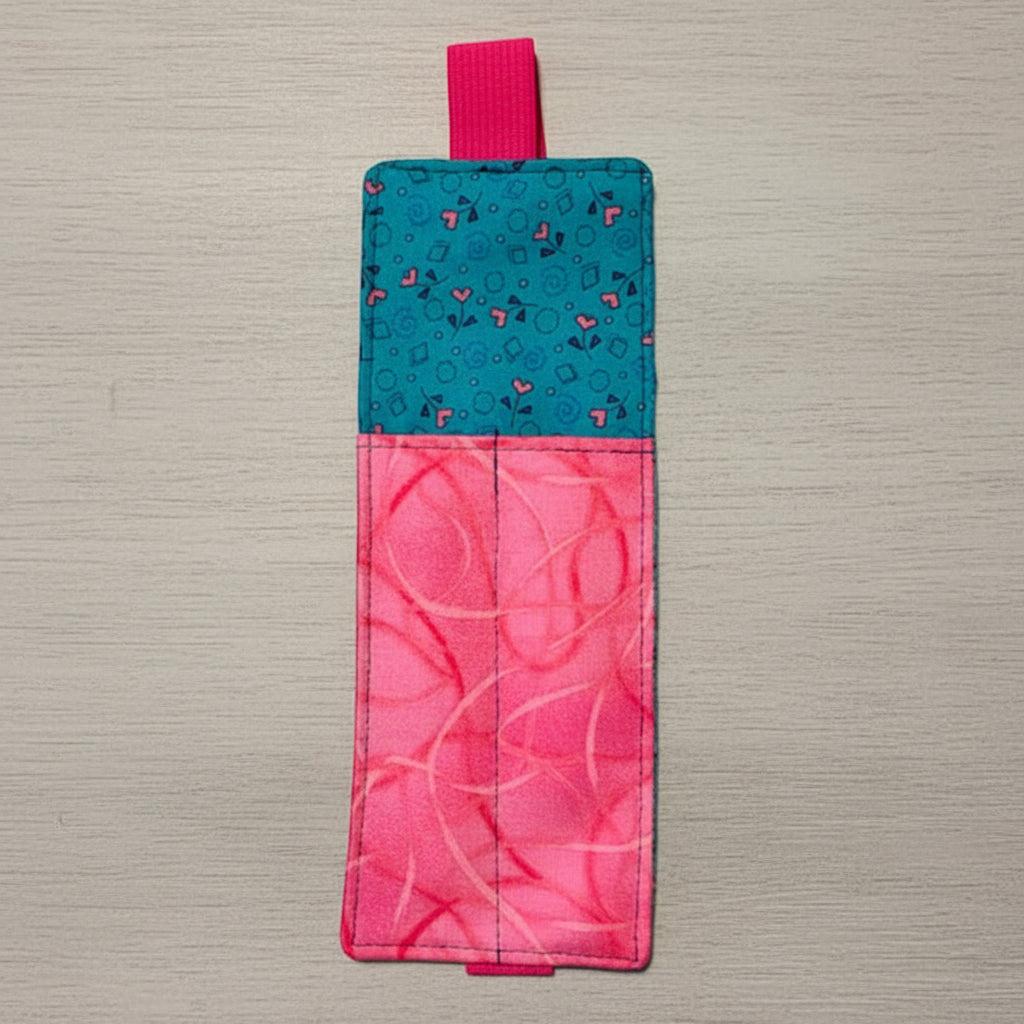 Two-tone pink and blue fabric bookmark on a light gray background