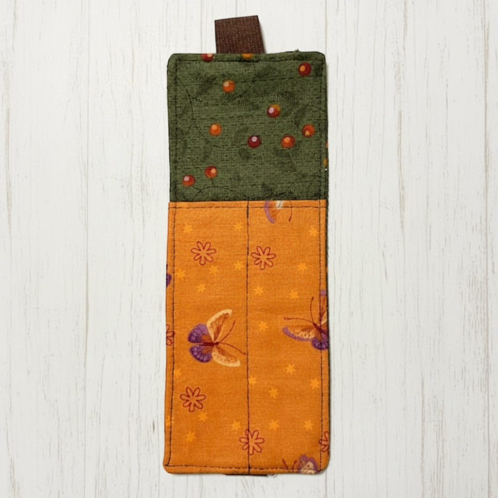 Fabric bookmark with green top and orange bottom featuring floral patterns 