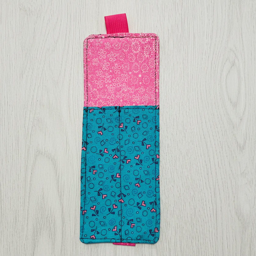 Two-tone pink and blue fabric pouch on a light gray background
