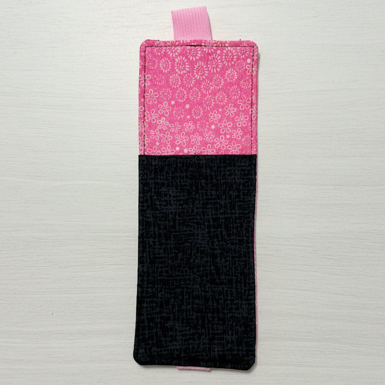 Two-tone pink and black fabric pouch on a light gray background