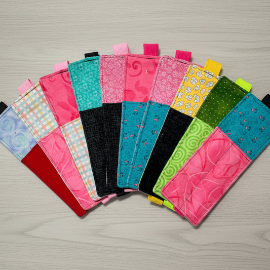 Collection of colorful fabric pouches with various patterns on a light gray background