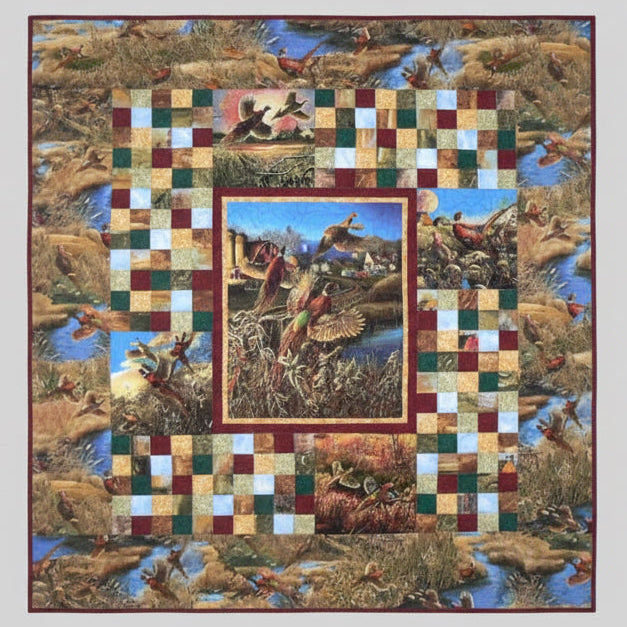 Quilt with checkered border and central scene of birds in flight over water